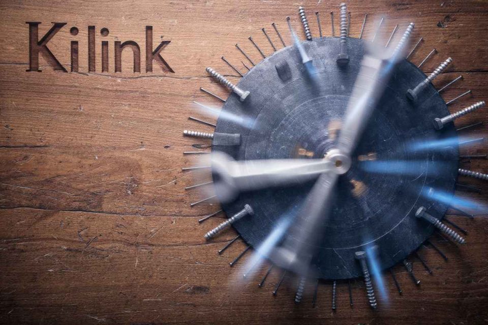 Cadran d'horloge unique avec vis métalliques sur bois, gravé 'Kilink', symbolisant l'innovation.